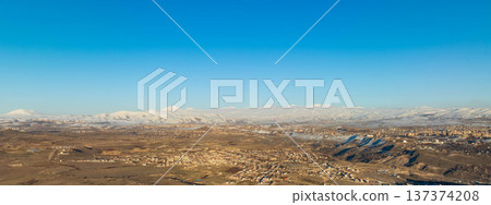 Widespread desert plain with distant mountains covered in snow 137374208