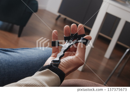 closeup of a man using a finger trainer 137375673