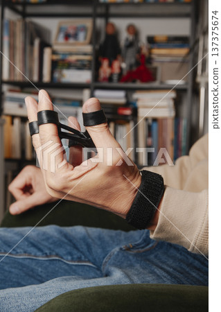 a man exercises his hand with a grip trainer 137375674