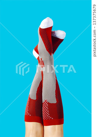a man raises his legs wearing compression socks 137375679