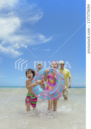 A family of four playing in the summer sea 137375694