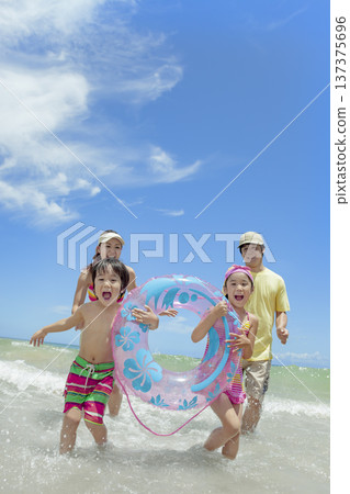 A family of four playing in the summer sea 137375696