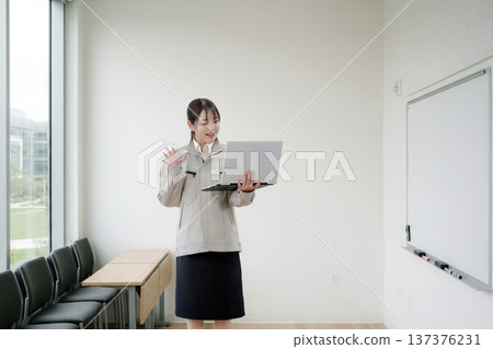 A woman greets the screen in a training room A woman greets the screen in a training room 137376231