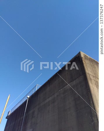 Concrete wall of the Kita-Chiba Regional Waterworks Corporation connecting well and the blue winter sky Concrete wall of the Kita-Chiba Regional Waterworks Corporation connecting well and the blue winter sky 137376247