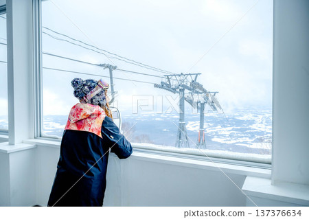 年輕女子從窗戶望向滑雪場。 137376634