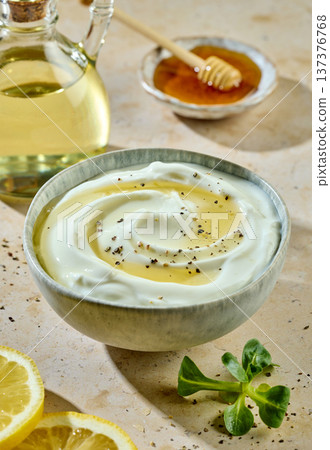 Greek yogurt bowl with honey and spices on sunny kitchen table with ingredients Greek yogurt bowl with honey and spices on sunny kitchen table with ingredients 137376768