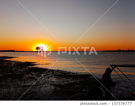 在非洲波札那喬貝河上乘船遊覽,欣賞日落美景。 在非洲波札那喬貝河上乘船遊覽,欣賞日落美景。 137376777