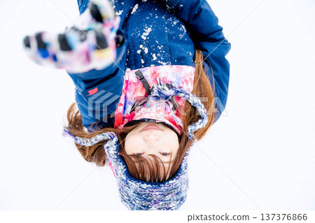 一位身穿滑雪服的年輕女子在雪坡上玩雪。 一位身穿滑雪服的年輕女子在雪坡上玩雪。 137376866