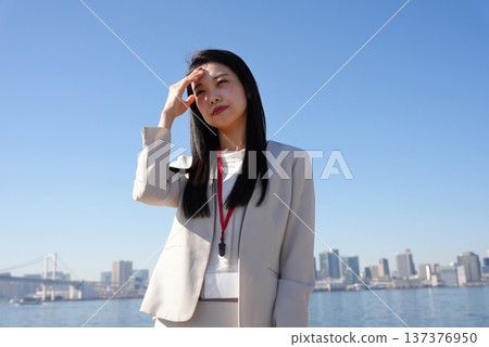 A young businesswoman blocking the dazzling sunlight 137376950