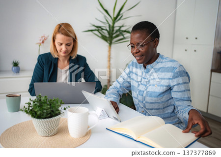 Diverse women working remotely from home office Diverse women working remotely from home office 137377869