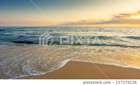 sandy sea beach background on hot summer dawn. low angle view. empty seascape scenery with calm waves. beauty seashore wallpaper. peaceful sozopol resort bay photo for advertising 137378236