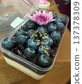 Delicious Blueberry Cheesecake Dessert with Fresh Berries and Pink Floral Garnish 137378309