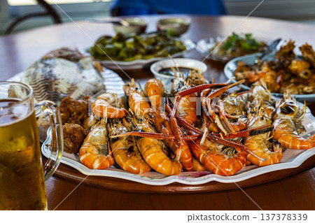Grilled Shrimp On Plate Dining Table Thai Food, An photo of juicy grilled shrimp on a dining table fresh ingredients and bold Thai flavors, for culinary documentary and food lifestyle. Grilled Shrimp On Plate Dining Table Thai Food, An photo of juicy grilled shrimp on a dining table fresh ingredients and bold Thai flavors, for culinary documentary and food lifestyle. 137378339
