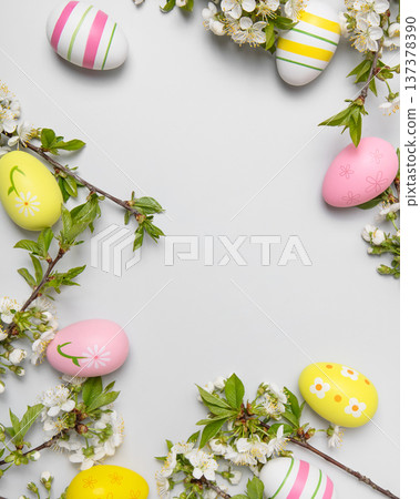 Easter colored painted eggs and blooming spring cherry branches on gray background in shape of frame with space for text and greetings. Easter and spring concept. Spring background Easter colored painted eggs and blooming spring cherry branches on gray background in shape of frame with space for text and greetings. Easter and spring concept. Spring background 137378390