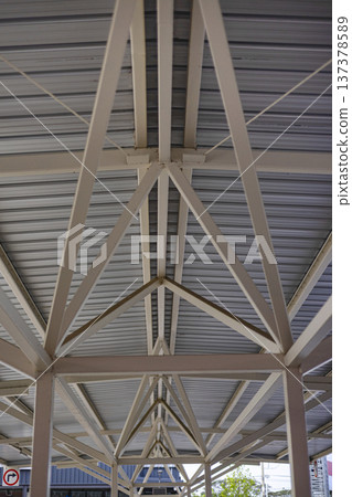 Under Large Steel Roof Structure, A grand photo of under large steel structure, massive beams and trusses towering in light on concrete floor, for modern architecture or engineering documentary. Under Large Steel Roof Structure, A grand photo of under large steel structure, massive beams and trusses towering in light on concrete floor, for modern architecture or engineering documentary. 137378589