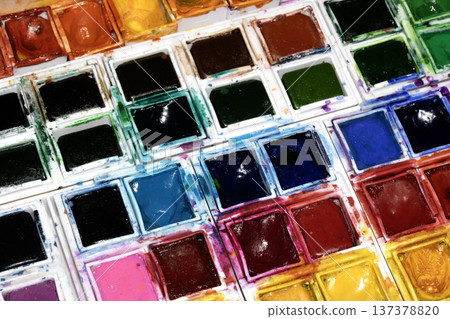 A Colourful Watercolour Painters Pallet of Messy Used Half Pan Paints Creative Background A Colourful Watercolour Painters Pallet of Messy Used Half Pan Paints Creative Background 137378820