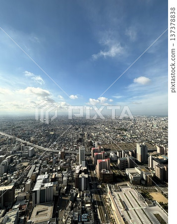 Looking down from the observation deck at the vast Osaka cityscape and blue sky Looking down from the observation deck at the vast Osaka cityscape and blue sky 137378838