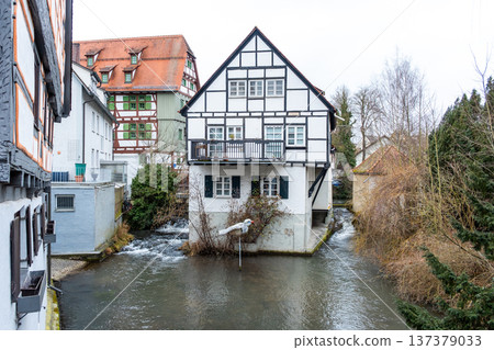 A tranquil canal in the fishermans quarter of Ulm, Germany. Reflections of colorful buildings line the water edge, creating a serene urban scene. A tranquil canal in the fishermans quarter of Ulm, Germany. Reflections of colorful buildings line the water edge, creating a serene urban scene. 137379033