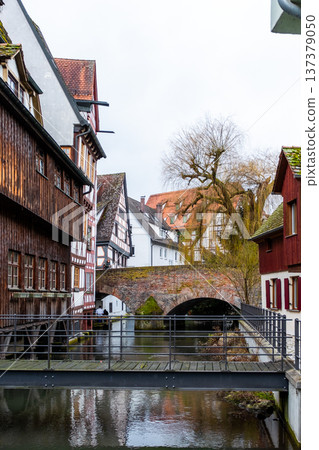 A tranquil canal in the fishermans quarter of Ulm, Germany. Reflections of colorful buildings line the water edge, creating a serene urban scene. A tranquil canal in the fishermans quarter of Ulm, Germany. Reflections of colorful buildings line the water edge, creating a serene urban scene. 137379050
