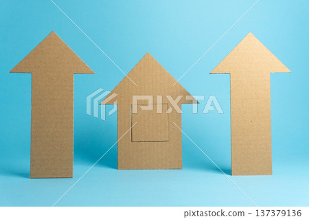 Cardboard arrows and house shapes are arranged on a blue background for a design project or craft activity Cardboard arrows and house shapes are arranged on a blue background for a design project or craft activity 137379136