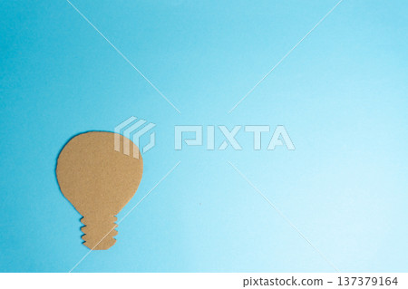 Creative light bulb shape made from cardboard on a blue background Creative light bulb shape made from cardboard on a blue background 137379164