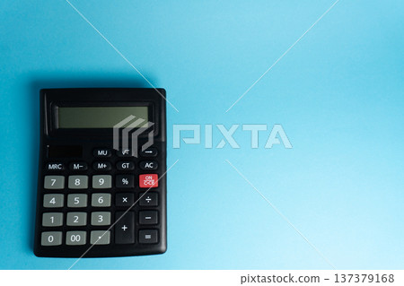 Calculator sits on blue surface used for basic math tasks and calculations during study or work hours Calculator sits on blue surface used for basic math tasks and calculations during study or work hours 137379168