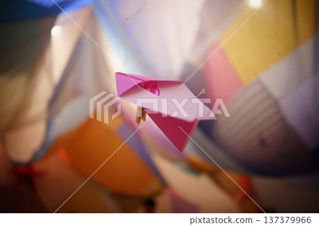 Dreamy pink paper airplanes between colorful curtains Dreamy pink paper airplanes between colorful curtains 137379966