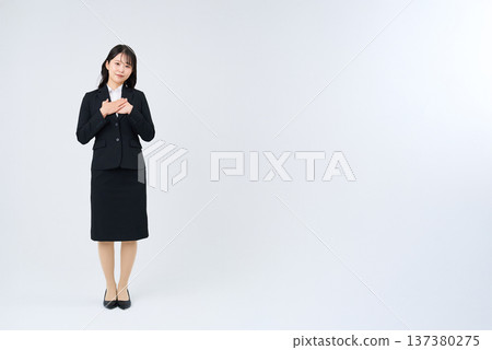 一位女商人擺姿勢,一手放在胸前。 一位女商人擺姿勢,一手放在胸前。 137380275