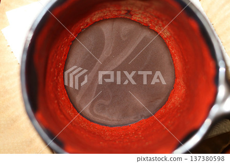 Red and black ceramic coffee cup with coffee grounds. Red and black ceramic coffee cup with coffee grounds. 137380598