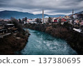 Historic Cityscape with Mosque and River Under Dramatic Sky 137380695