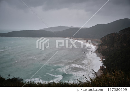 Dramatic Coastal Bay with Waves and Mountainous Shoreline 137380699