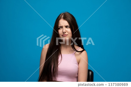 Young woman expressing disgust, a grimace of dislike and skepticism on her face, disapproval concept Young woman expressing disgust, a grimace of dislike and skepticism on her face, disapproval concept 137380989