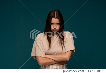 Young angry woman pouting with crossed arms, feeling frustrated and upset on a minimal teal background 137381045