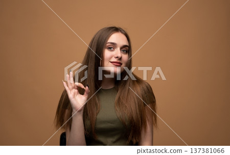 Young woman showing okay gesture, expressing agreement, success, approval, and satisfaction with a smiling face Young woman showing okay gesture, expressing agreement, success, approval, and satisfaction with a smiling face 137381066