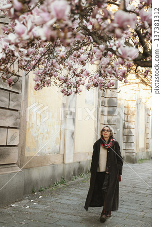 Woman Walking Under Blooming Magnolia Trees Woman Walking Under Blooming Magnolia Trees 137381312