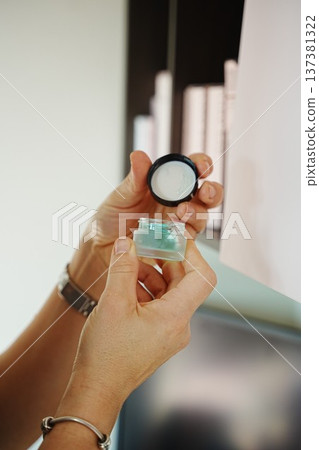 Hands Holding Eyeshadow Jar with Lid Opened Hands Holding Eyeshadow Jar with Lid Opened 137381322