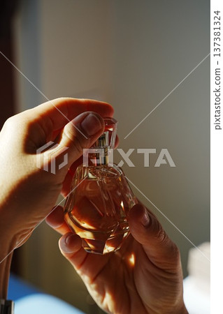 Hands Holding Perfume Bottle with Engraving 137381324