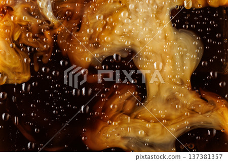 Macro shot of milk mixing into iced coffee with condensation 137381357