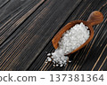 sea salt in wooden scoop on dark wooden table 137381364