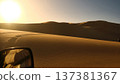 Driving Through Desert Sand Dunes at Sunset 137381367