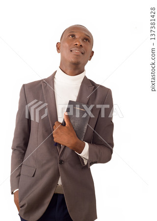young man standing in jacket and holding a Bible. young man standing in jacket and holding a Bible. 137381428
