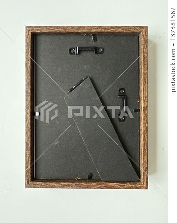Wooden picture frame back with hangers on light surface, ideal for art display or home decor. 137381562