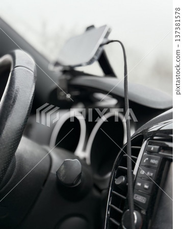 Car interior with smartphone mount, steering wheel, and dashboard in focus, perfect for background Car interior with smartphone mount, steering wheel, and dashboard in focus, perfect for background 137381578