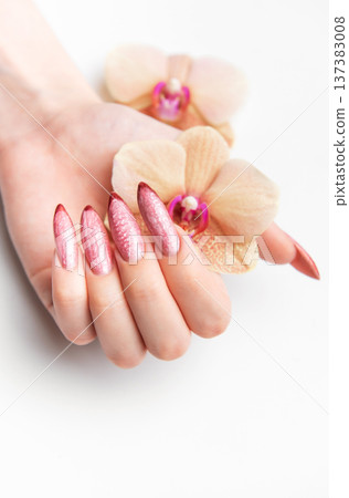 Woman's hand holding orchid showcasing beautiful manicure Woman's hand holding orchid showcasing beautiful manicure 137383008
