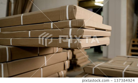 Close-up of stacked cardboard packages strapped and ready for shipping in a warehouse Close-up of stacked cardboard packages strapped and ready for shipping in a warehouse 137384924