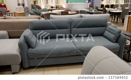 Contemporary fabric sofa for sale in a retail furniture store showroom Contemporary fabric sofa for sale in a retail furniture store showroom 137384932