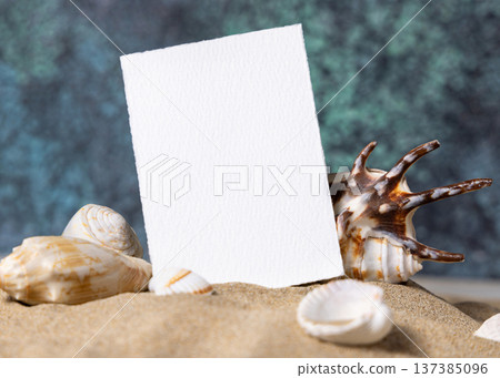Mockup of blank vertical card on sand near seashells and blue ocean back, beach wedding stationery Mockup of blank vertical card on sand near seashells and blue ocean back, beach wedding stationery 137385096