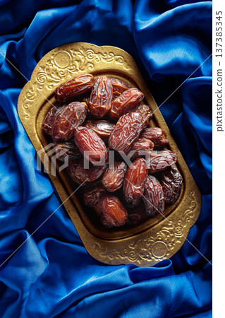 Dates on a golden platter. 137385345