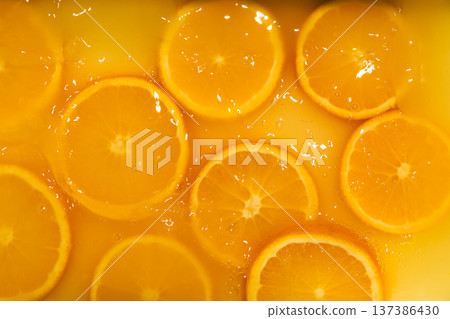Fresh slices of oranges splashing in orange juice. Fruity bright background Fresh slices of oranges splashing in orange juice. Fruity bright background 137386430