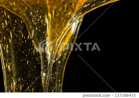 Flowing golden honey with air bubbles texture. Flowing golden honey with air bubbles texture. 137386433
